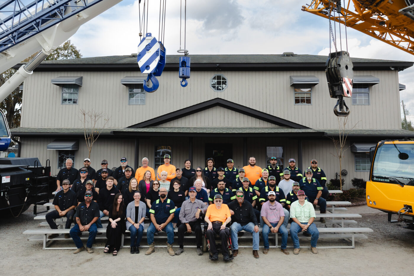 Dozier Crane employees sitting on scaffolding surrounded by cranes