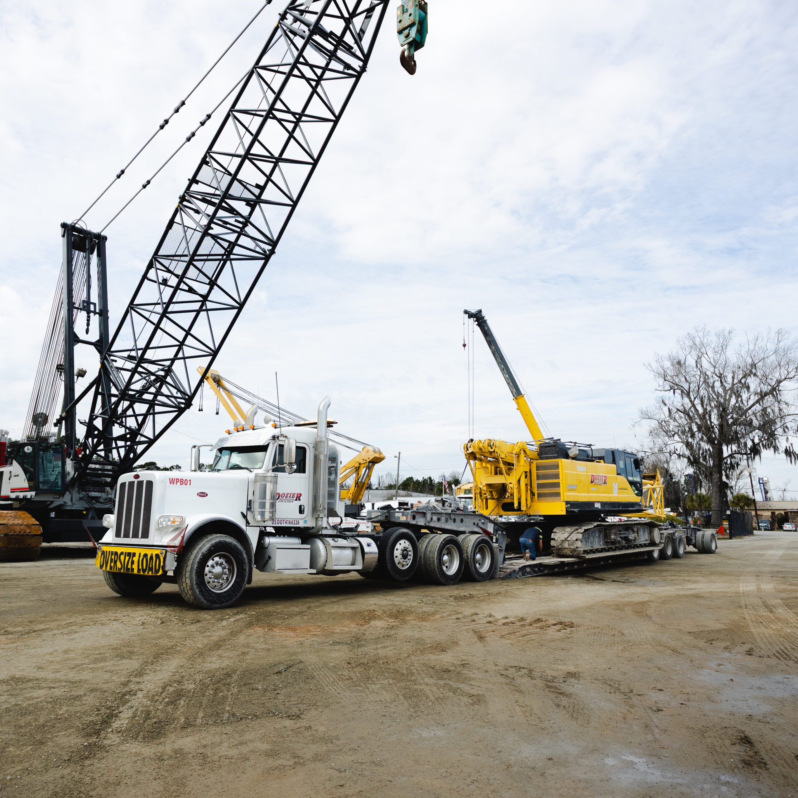 specialized logistics and heavy hauling equipment pulling a crane to a construction site